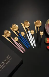 Dettaglio set posate in acciaio inossidabile, manico colorato cucchiaio forchetta coltello oro.