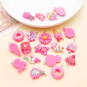 Detalle de dijes de resina rosa con ositos y rosquillas para hacer joyería DIY artesanal.