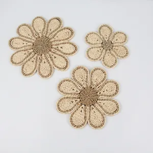 Handmade straw woven flower placemat detail, natural plant fiber coaster texture close up.