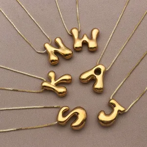 Gros plan détaillé de pendentifs lettres dorées en relief 3D avec chaînes délicates.