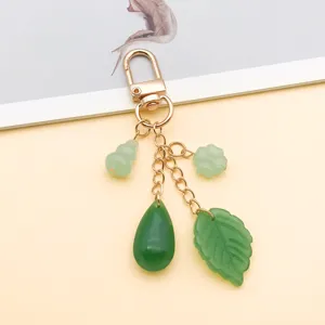 Llavero colgante múltiple dorado con dijes de calabaza y hoja estilo jade detalle