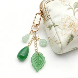 Primer plano detallado de una exquisita bolsa bordada china con colgante de jade verde y oro.