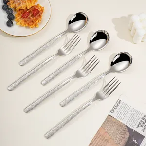 Ensemble de couverts en acier inoxydable avec poignées martelées, cuillères et fourchettes.