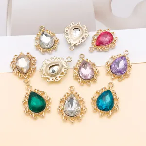 Detailansicht von bunten Tropfen-Glasanhängern mit filigranen Goldfassungen für DIY-Schmuck.