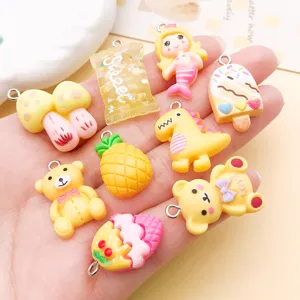 Gros-plan de pendentifs mignons en résine, breloques colorées d'animaux et fruits pour bijoux.