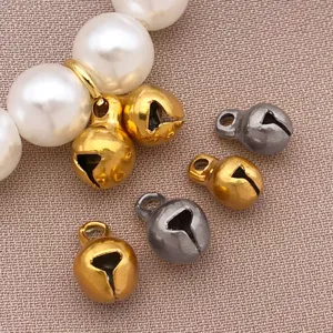 Primo piano di piccoli ciondoli a campana in acciaio inossidabile da 5/6 mm per creazione di gioielli.