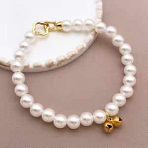 Bracciale di perle con chiusura a cuore dorata e campanelli per animali o accessori fai da te.