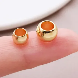 Detailed view of smooth gold tone large hole metal spacer beads for DIY jewelry making crafts.