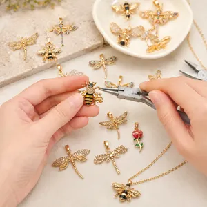 Detailaufnahme von vergoldeten Zirkon Biene und Libelle Anhänger DIY Schmuckzubehör.