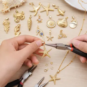 Close-up DIY jewelry making scene showing gold starfish pendants and crafting tools on wood.