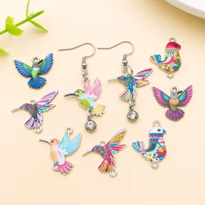 Close-up detail of colorful hummingbird enamel charms and earrings for DIY jewelry making.