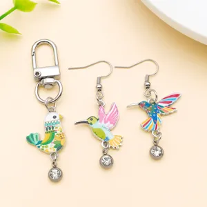 Detailed close-up of colorful enameled hummingbird charms, keyring and matching earrings set.