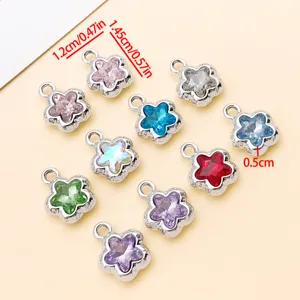 Détail de pendentifs en métal fleur étoile cristal coloré, accessoires bijoux.