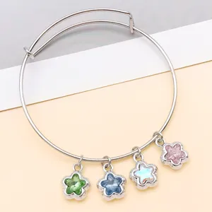 Bracelet jonc extensible argenté avec charmants cristaux de fleurs, gros plan détaillé.