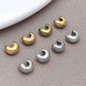 Detailed shot of C-shaped crimp covers and end beads in gold and silver, perfect for DIY jewelry.