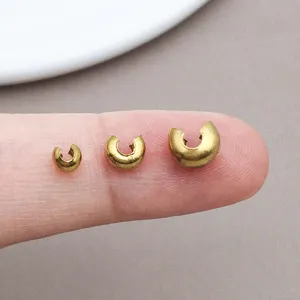Close-up of gold plated stainless steel crimp cover beads, C-shaped open jewelry charms.