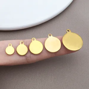 Detailed close-up of golden blank round metal charms pendants for DIY handmade jewelry crafting.