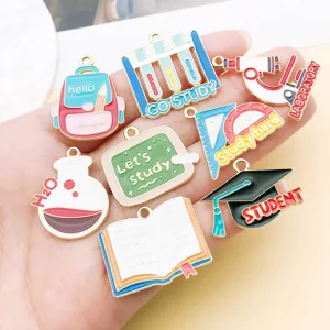 Close-up detail of mixed enamel graduation school theme metal alloy charms for DIY jewelry making.