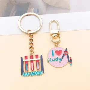 Detailed view of cute study theme metal enamel keychains featuring test tube and compass charms.