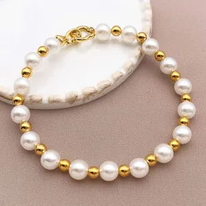 Vue de détail rapprochée du bracelet de perles et de perles dorées, accessoire de mode.
