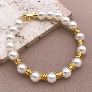 Elegantes Perlenarmband mit goldtexturierten Abstandsperlen und glänzendem Verschluss modisch.