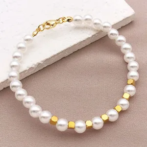 Dettaglio bracciale di perle e perle quadrate dorate, elegante accessorio gioiello fai da te.
