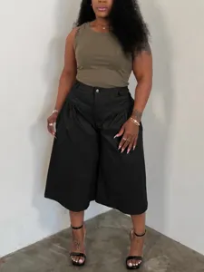 Plus size women's casual outfit featuring a sleeveless ribbed tank top and pleated wide leg pants.
