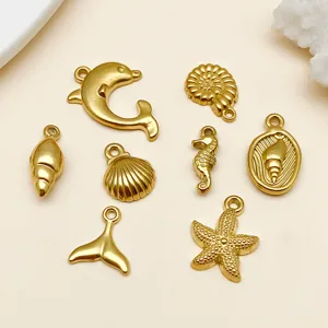 Detailopname van gouden oceaan thema hangers met zeester zeepaardje en dolfijn sieraden.