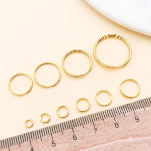 Detail view of assorted gold split rings and jump rings showing various sizes with a ruler.