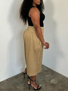 Detail view of plus-size khaki wide-leg pants featuring a stylish high-waisted pleated design.