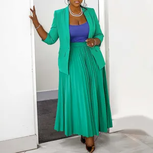 Green blazer, blue top and pleated maxi skirt suit set. Detailed view of women fashion outfit.
