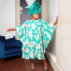 Plus size green floral kimono sleeve kaftan dress paired with matching statement hat and silver bag.