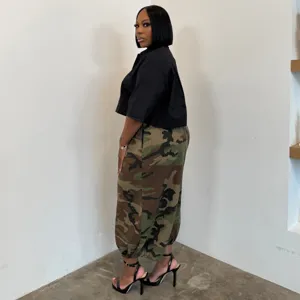 Pantalones harén de camuflaje de talla grande para mujer con top negro, estilo casual.