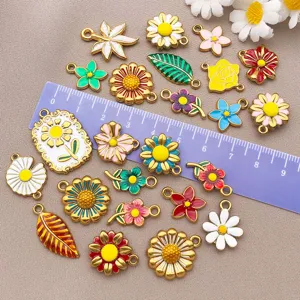 Close-up of colorful enamel flower charms, daisy and sunflower pendants for DIY jewelry making.