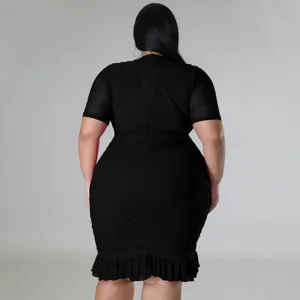 Detailed view of plus size black dress featuring sheer mesh sleeves and stylish ruffle hem.