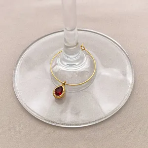 Detail view of stainless steel gold hoop with red teardrop stone pendant for DIY jewelry design.