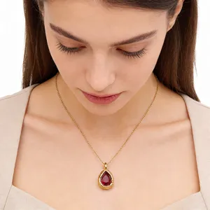 Exquisite gold chain necklace featuring a red teardrop gemstone pendant detail view.