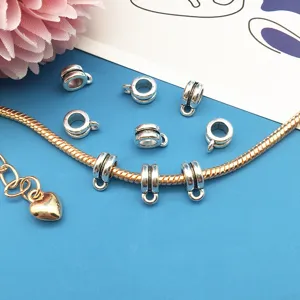 Detail shot of silver DIY bail beads and charm connectors for custom charm bracelets.