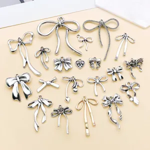 Detailed view of mixed alloy bow charms for DIY jewelry making and keychains accessories.
