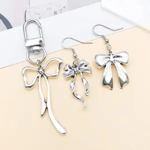 Silver bow keychain and earrings set alloy DIY jewelry accessories fine detail display.