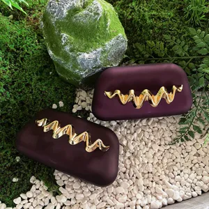 Matte box clutch evening bag for women with elegant gold metal wave decoration for party.