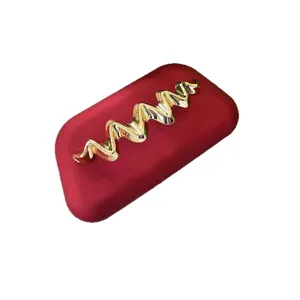 Red matte box clutch bag with gold wavy metal decoration, elegant evening bag for women.