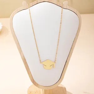 Detail van afstudeerhoed hanger ketting, elegante gouden ketting sieraden close up view.