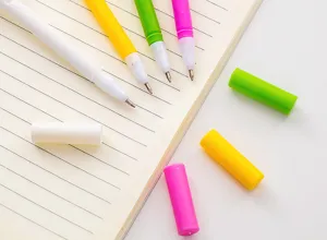 Colorful gel pens detail shot showcasing vibrant hues and matching caps on a lined notebook.