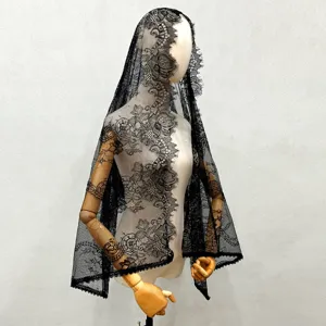 Detail shot of black lace bridal veil on a wooden mannequin, showing intricate floral patterns.