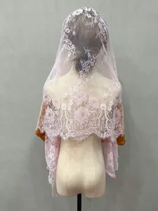 Pink lace veil detail showing delicate floral pattern and fringe trim for bridal photo styling.
