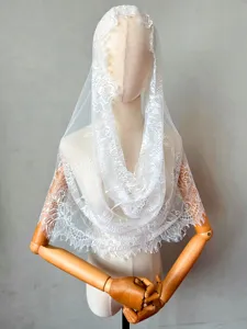 Detailed view of the elegant white lace bridal veil featuring delicate floral patterns.