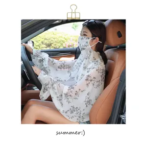 Detailed view of floral sun protection shawl and sleeves worn inside car for driving.