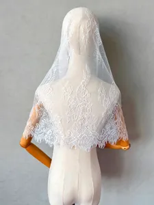 White lace bridal veil detail shot, elegant floral embroidered wedding headpiece.