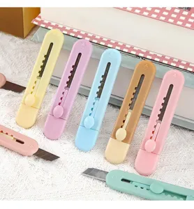 Primo piano di mini cutter pastello con lame retrattili pratiche per tagliare carta.